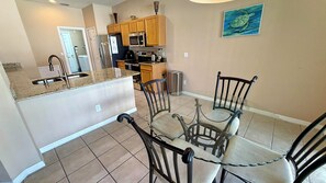 A kitchen with wooden cabinets, a stainless steel refrigerator, a microwave, and a coffee maker.