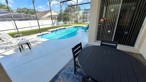 A pool area with a covered patio, lounge chairs, and a view of the neighborhood. - Envious Highlands Reserve pool home with recent upgrades. (Davenport)