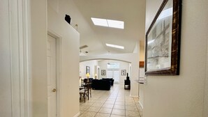 A spacious hallway with a dining area, a living room, and a kitchen.