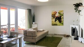 Een moderne woonkamer met een bank, een eettafel en een keukenhoek.