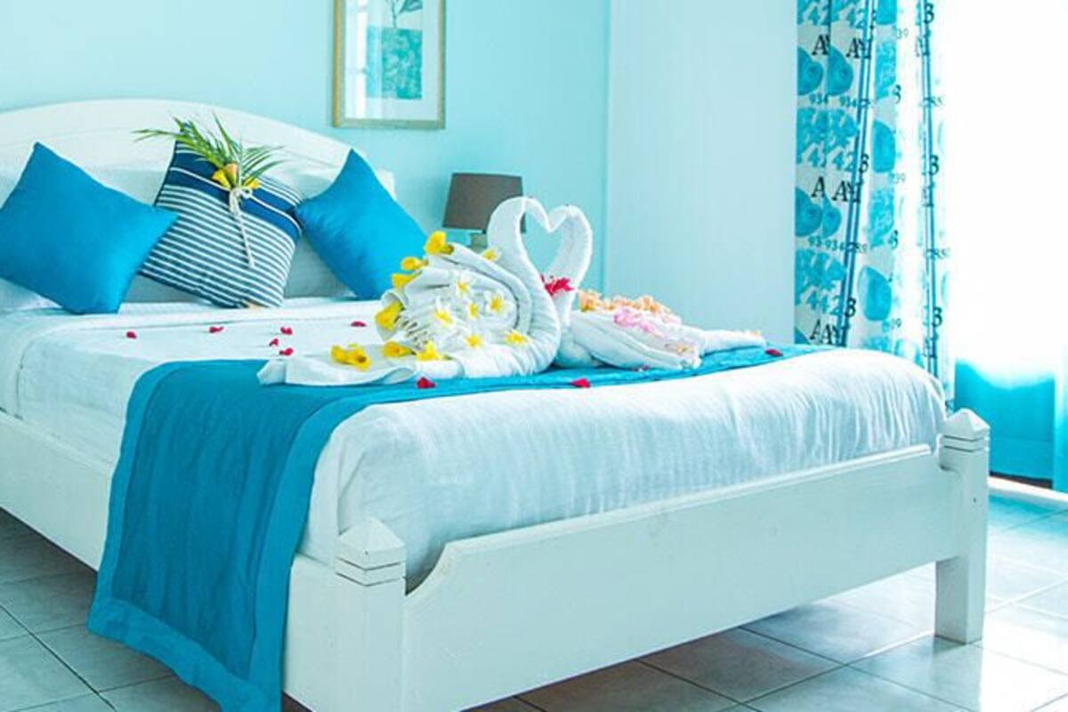 A neatly arranged bedroom with a bed, bedside tables, and a chair.
