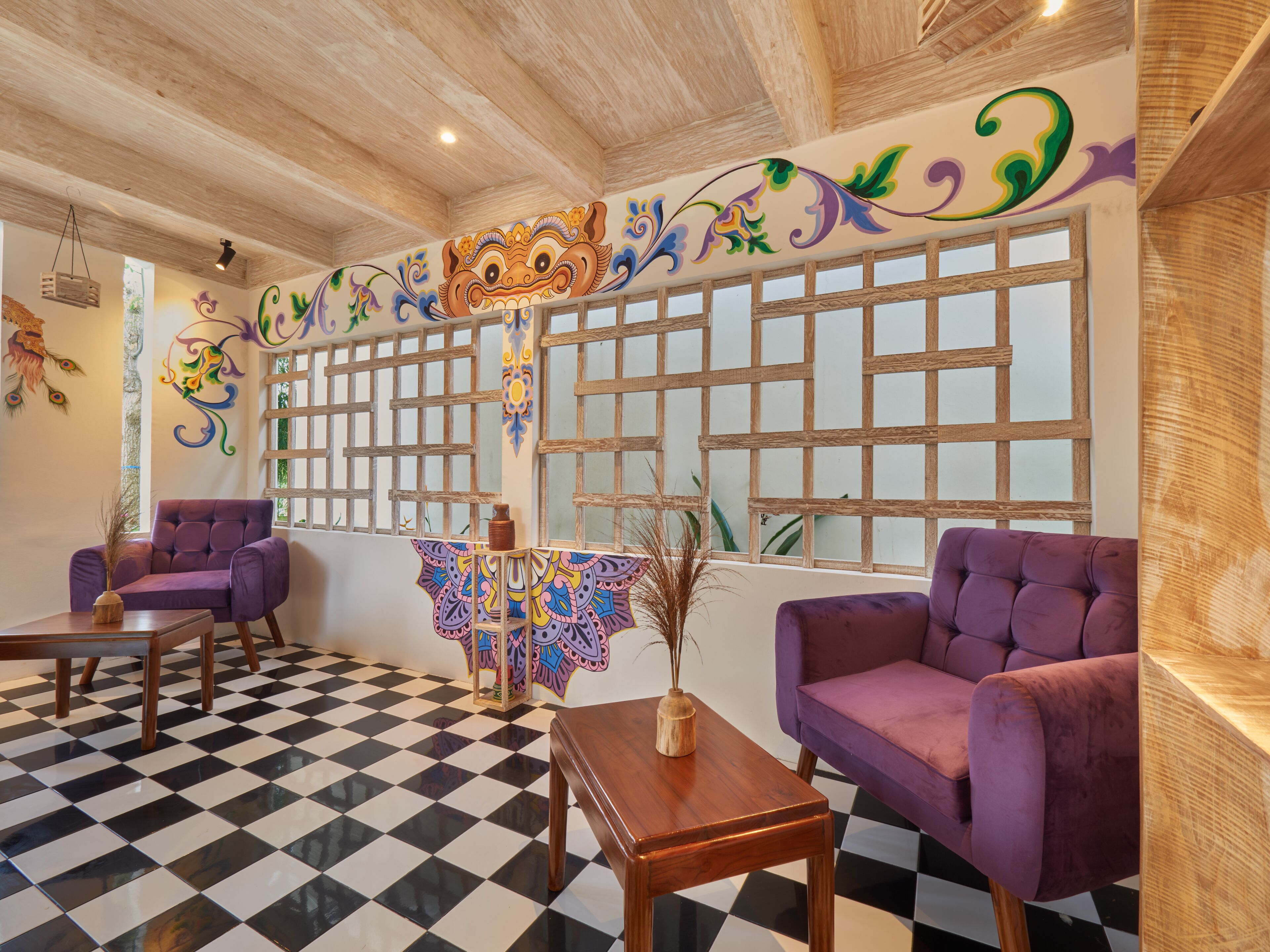 A room with checkered flooring, purple armchairs, a wooden table, and a decorative wall with a large number '3'.