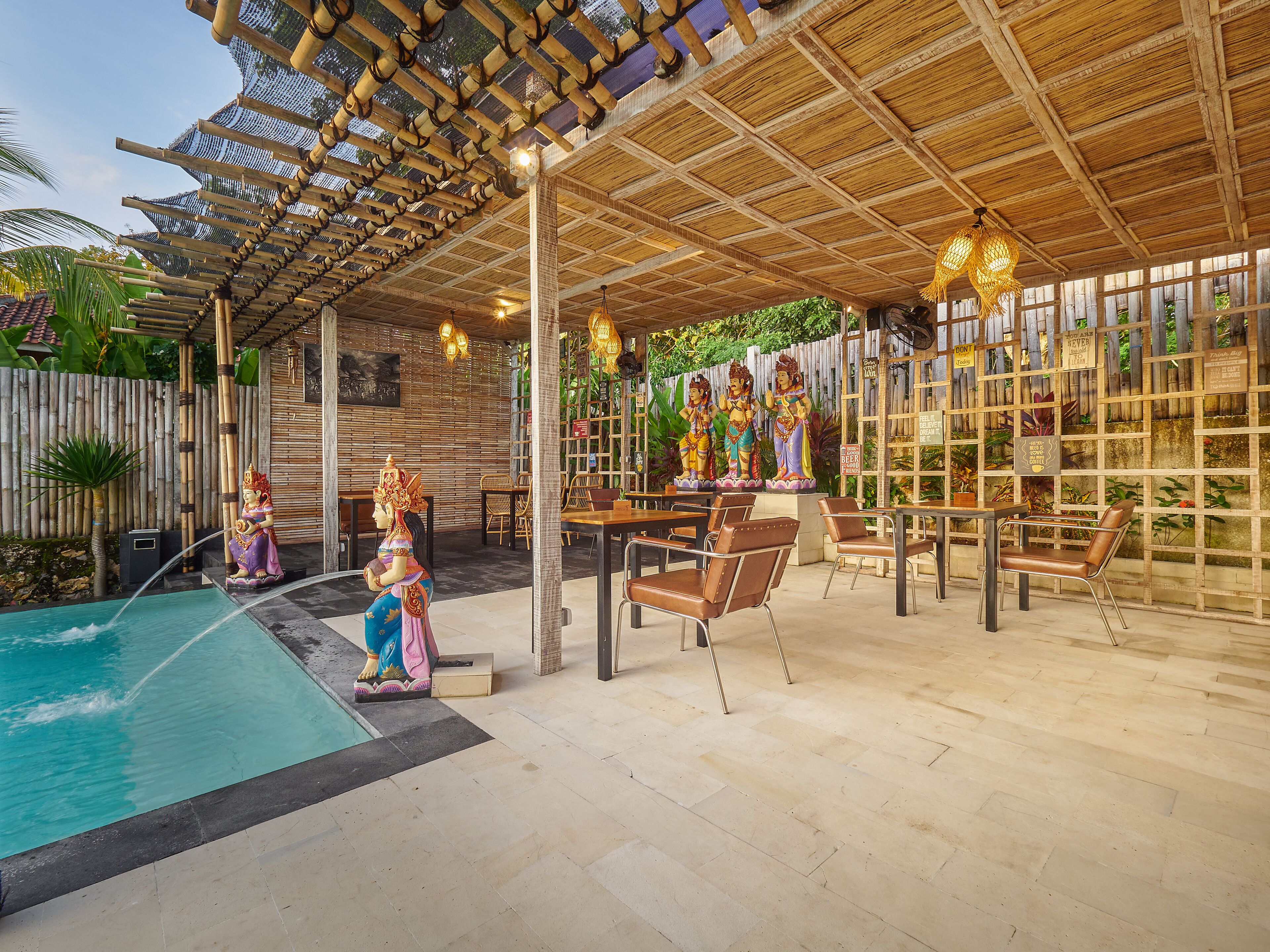 Un espacio al aire libre cubierto con piscina, asientos y estatuas decorativas.