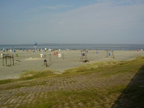 A beach with various structures and a clear view of the sea.