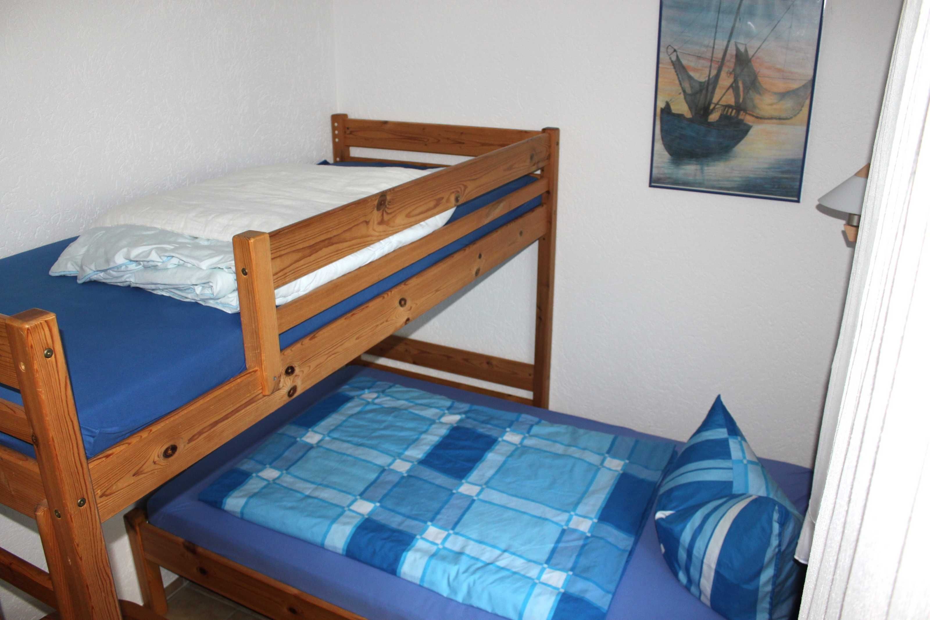 Een stapelbed met een blauwe matras en een houten frame.
