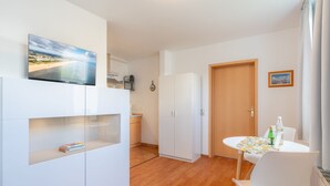 Una cocina moderna con armarios blancos, horno empotrado y un amplio ventanal.