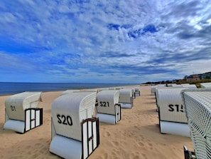 Beach chairs with price tags on a sandy beach.