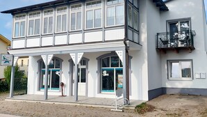 Ein zweistöckiges Gebäude mit einem Balkon im zweiten Stock.