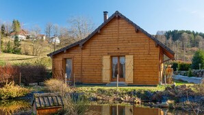 A wooden cabin with a gabled roof, a front door, and a small porch area.