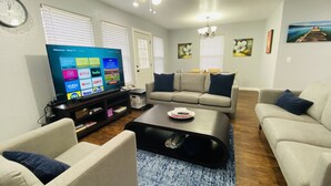 A living room with a flat-screen TV, two sofas, a coffee table, and a TV stand.