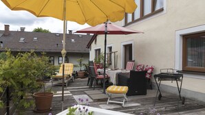 Une terrasse extérieure avec des sièges, une table et un barbecue.