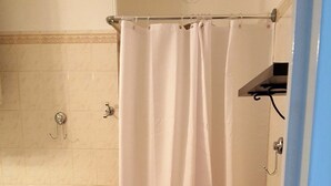 Un baño con ducha, inodoro y lavamanos.