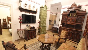 Een klassieke kamer met antieke meubels, waaronder een houten kast, een kast met een groen patroon en een grote spiegel.