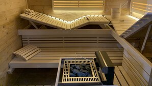 Eine Sauna mit Holzbänken und einem Steinkamin.