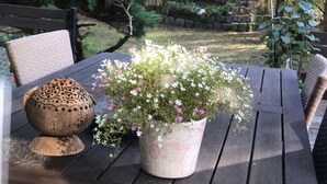 A wooden table with a potted plant and a decorative bowl. - Ferienhaus Waldoase für 2 - 3 Personen, Freistehend auf Eingezäuntem Grundstück (Beelitz)