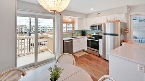 Une cuisine moderne avec des armoires blanches, des appareils en acier inoxydable et un grand îlot central.