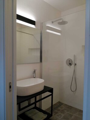 Kombination af bruser/badekar, hårtørrer, bidet, håndklæder