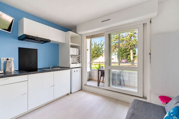 A modern kitchen with white cabinets, a black countertop, and a built-in oven.