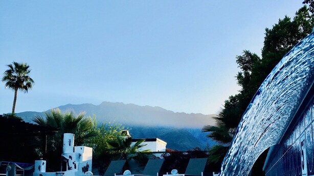 A pool with a waterfall feature, lounge chairs, and a view of mountains in the background. - Palm Springs Private Retreat Pool & Mountain Views (Palm Springs)