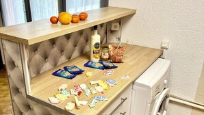 A kitchen area with a wooden countertop, a washing machine, and a window with curtains. - VILLA 200 M from the BEACH (Sainte-Marie-la-Mer)