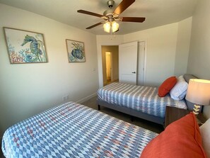 A bedroom with two beds, a ceiling fan, and artwork on the walls. - Modern 3BR Townhome Near Zion & Bryce | Sleeps 8 (Kanab)
