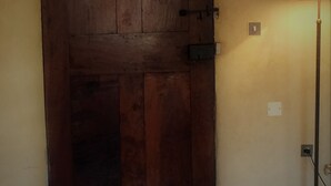 Eine geschlossene Holztür mit Riegel und Lichtschalter an der rechten Seite.