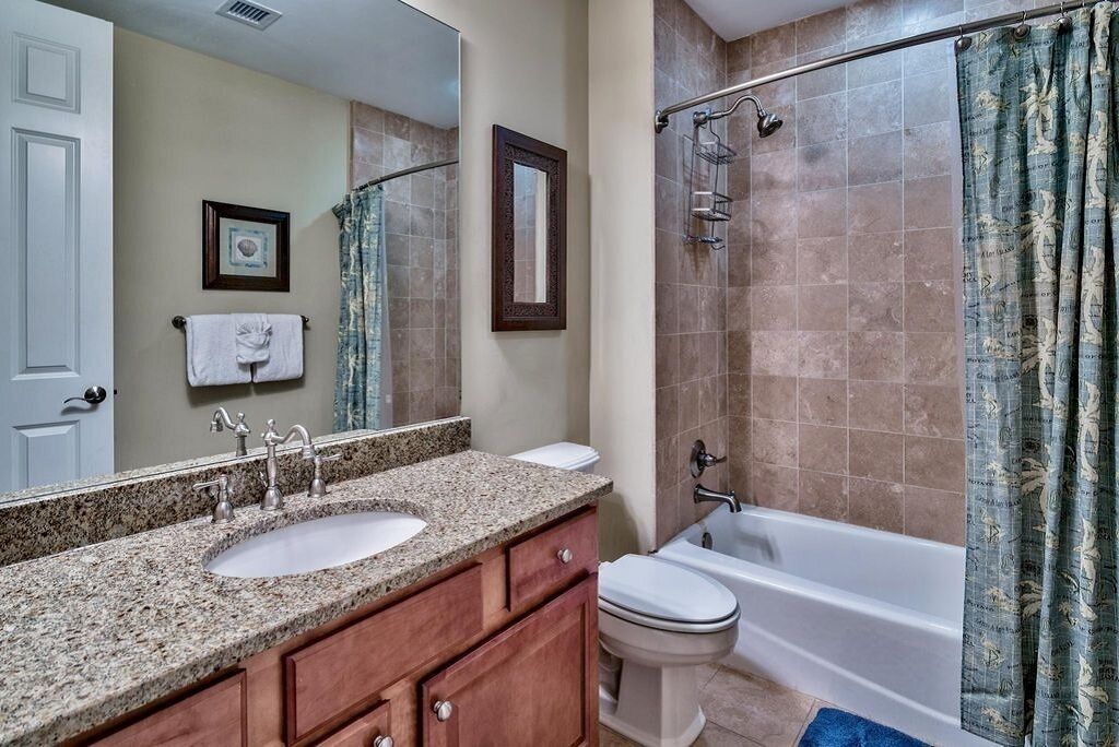 A bathroom with two sinks, a toilet, a bathtub, and a shower.