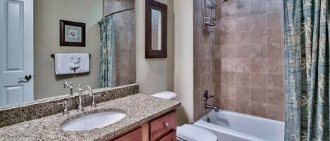 A bathroom with two sinks, a toilet, a bathtub, and a shower.