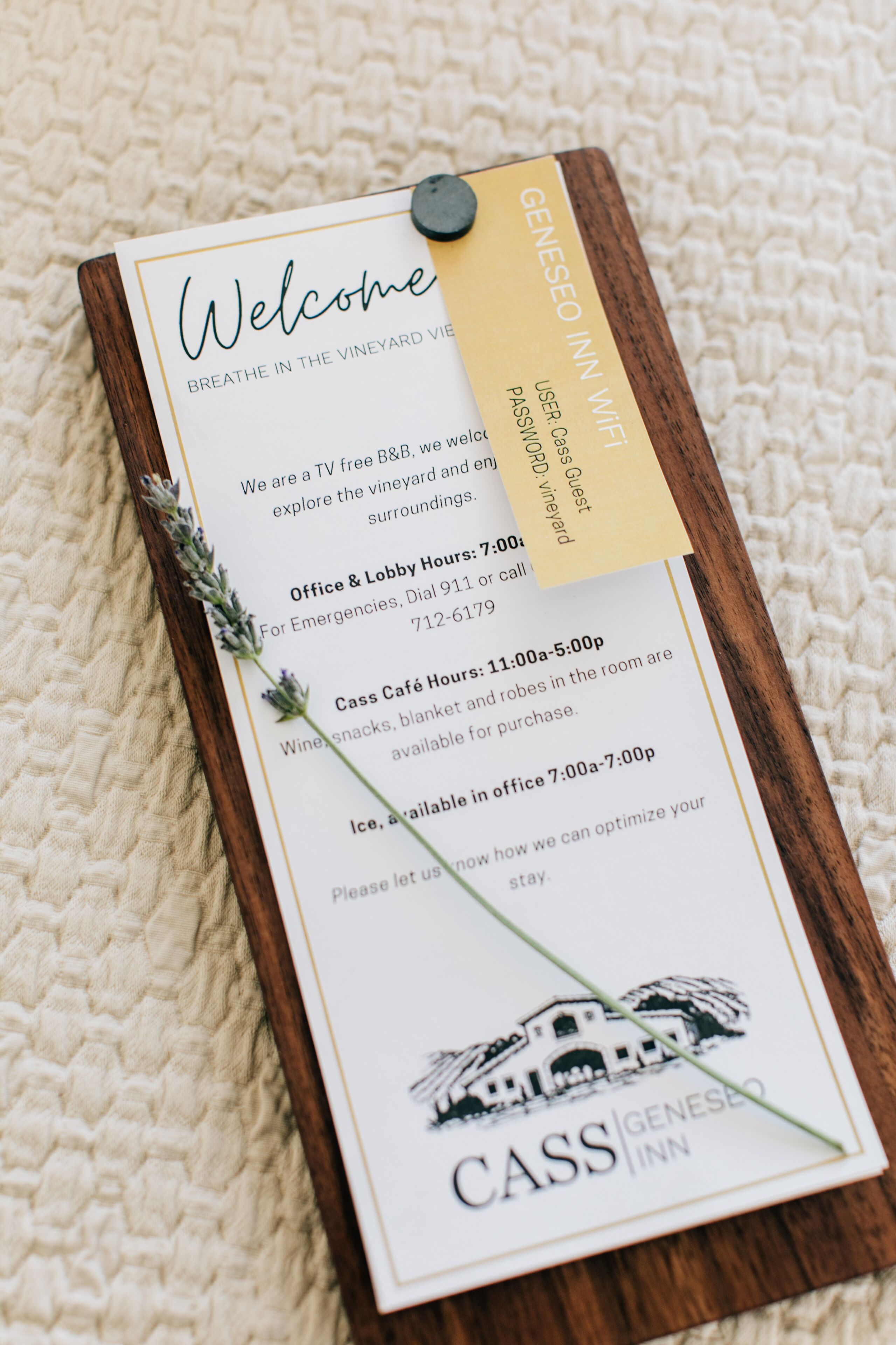 Tarjeta de bienvenida del Cass Geneseo Inn, que detalla servicios como un B&B sin televisión, horario de oficina y un café Cass con aperitivos de vino.