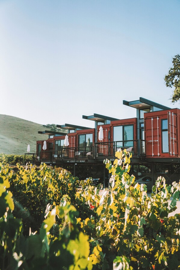 A modern building with large windows and balconies, situated in a vineyard. - Geneseo Inn (Paso Robles)