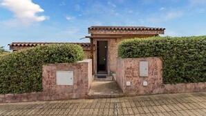 L'ingresso di un edificio con tetto in tegole, una porta e due quadri elettrici sui muri.