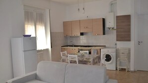 Um espaço compacto com cozinha americana, área de refeições e sofá.