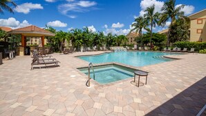 A pool area with lounge chairs and a gazebo.
