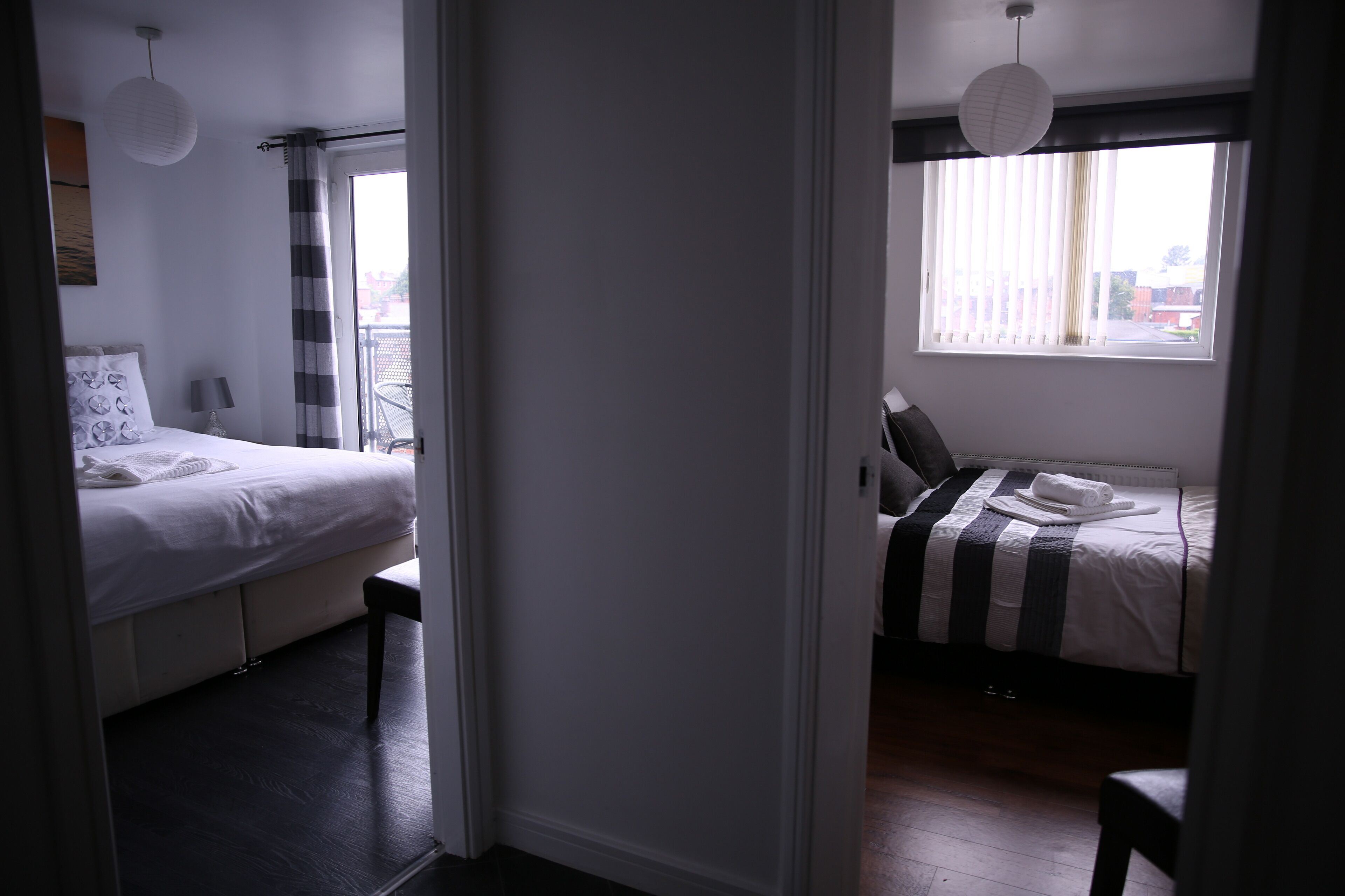 Habitació d'hotel amb dos llits, un balcó i vistes a la ciutat.