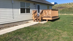 A single-story building with a wooden deck and a small porch.