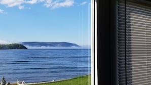 Vista de un lago con una isla distante y cielo despejado.