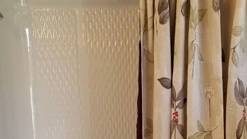 Un baño con bañera, inodoro y cortina de ducha.