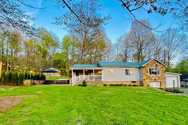 A two-story house with a stone exterior, a porch, and a well-maintained lawn.