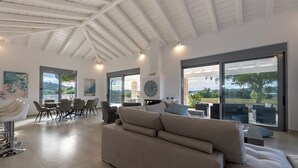 Un vaste espace de vie doté d’un haut plafond, de grandes fenêtres et d’un aménagement intérieur moderne.