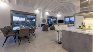 Une cuisine spacieuse dotée d’un grand îlot central, d’appareils électroménagers modernes et d’un coin repas avec une table ronde et des chaises.