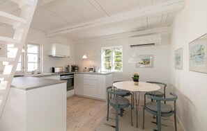 Enjoy meals in the spacious dining area with a round table and four chairs, surrounded by large windows.