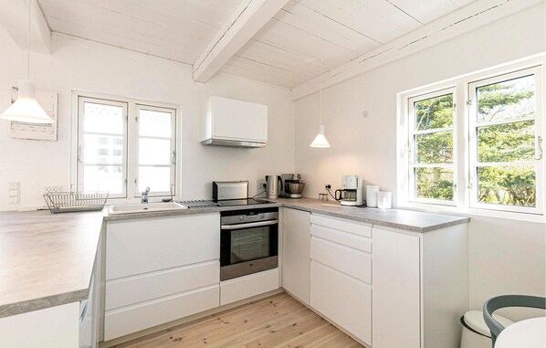 Enjoy cooking in this well-equipped kitchen with a stove, oven, microwave, sink, and ample counter space.