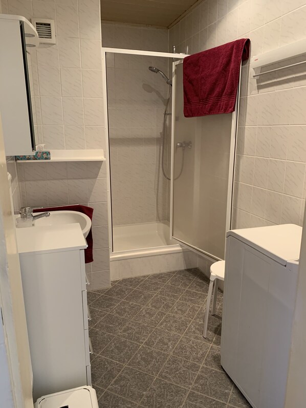 A bathroom with a shower, a sink, and a toilet.
