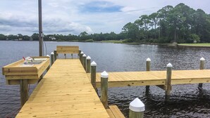A wooden pier extending into a lake with a bench and a small table with a toy figure. - L👀K!! 3 KING BEDS - Private Boat Ramp - FREE NETFLIX - Lakefront Lake Powell!!! (Panama City Beach)