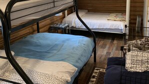 A cabin with bunk beds, a small table, and a potted plant. - Log cabin in the bitterroot mountains (Sula)