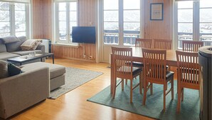 Una sala de estar acogedora con un sofá, una mesita de centro y un comedor con sillas y una mesa de madera.