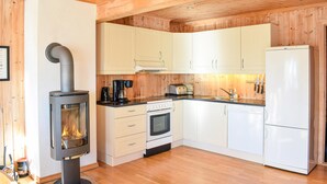 Una cocina moderna con armarios de madera, estufa integrada, refrigerador y tostadora.