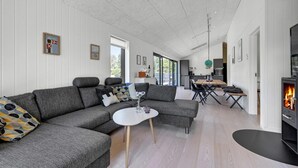 Una sala de estar moderna con un sofá modular, una mesita blanca y una chimenea.