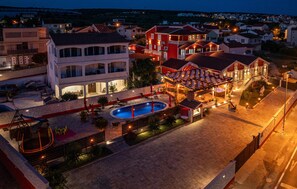 Un hotel con piscina, area salotto esterna e vista sul quartiere circostante.
