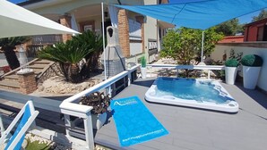 A hot tub, outdoor seating, and a blue banner with a website address.